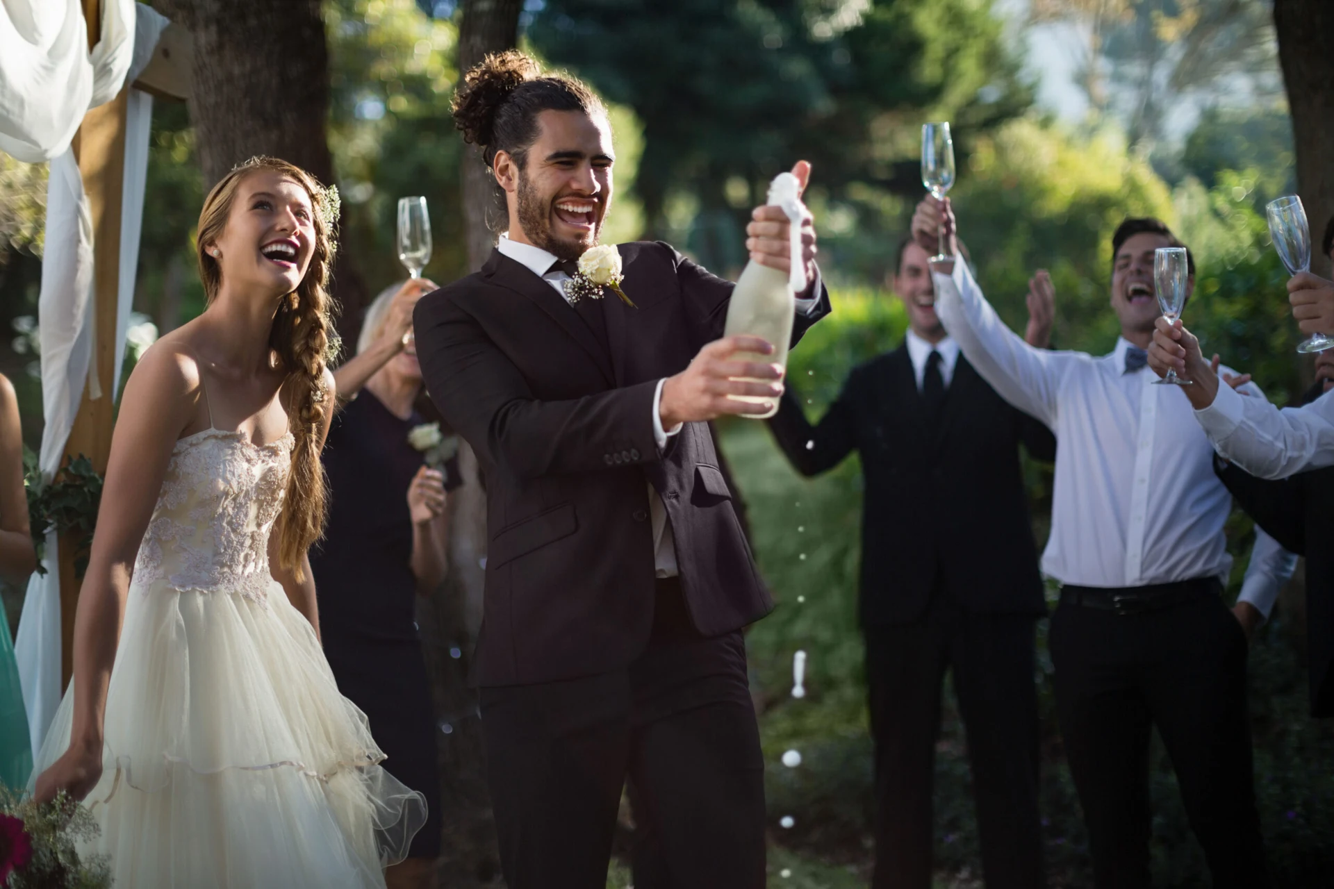 Bride and groom laughing as champagne is opened