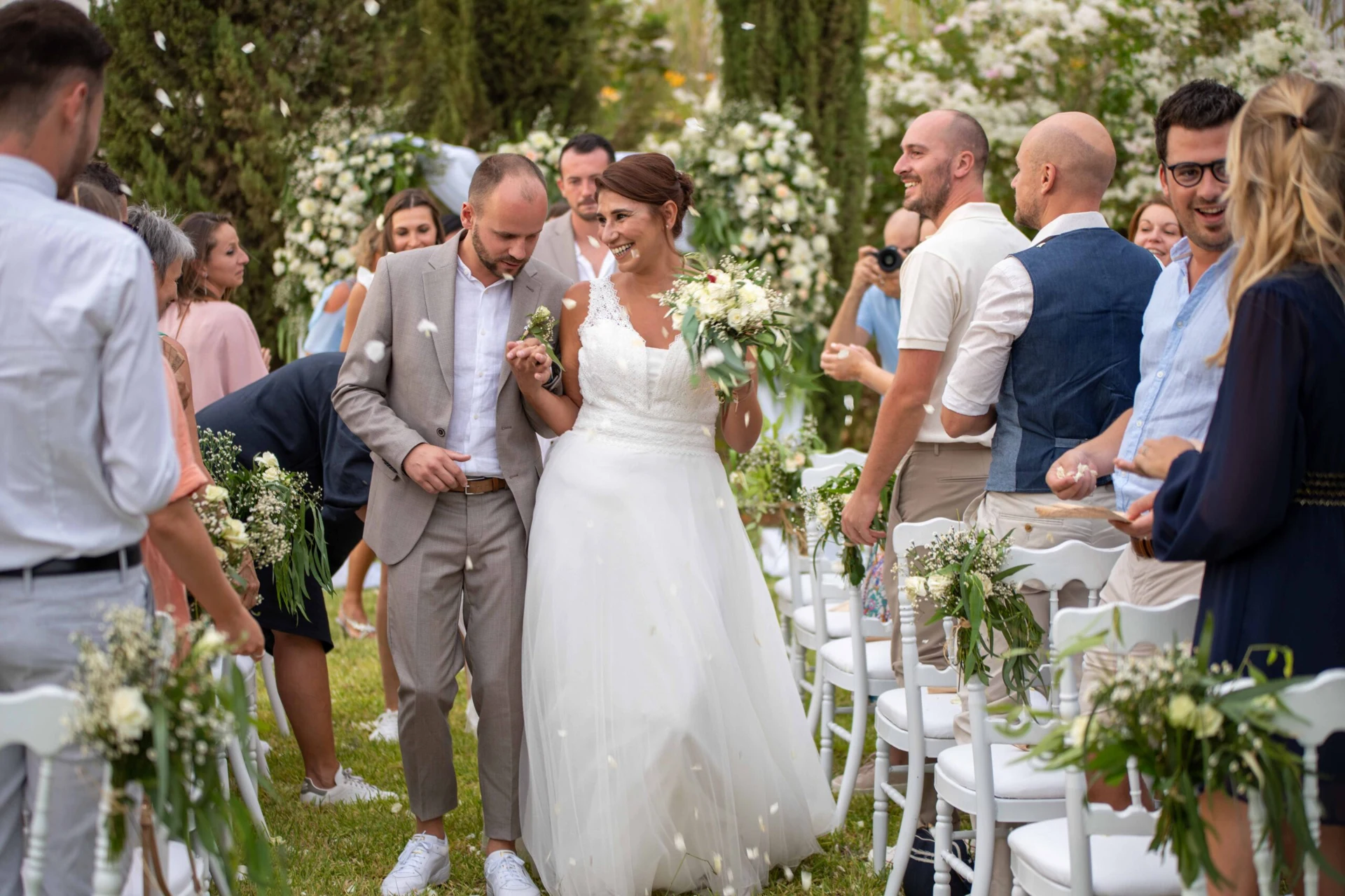 Newlyweds walking between their wedding guests