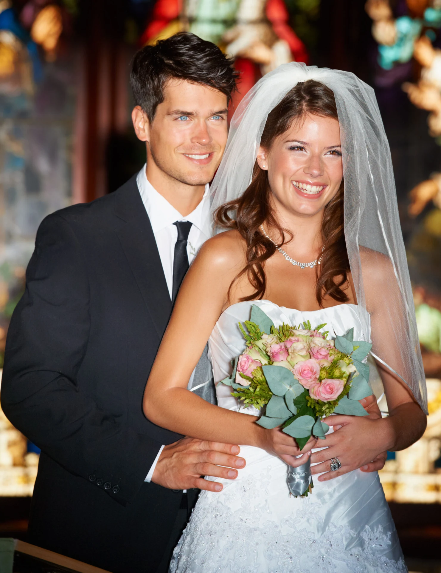 Newlyweds holding a colorful bouquet