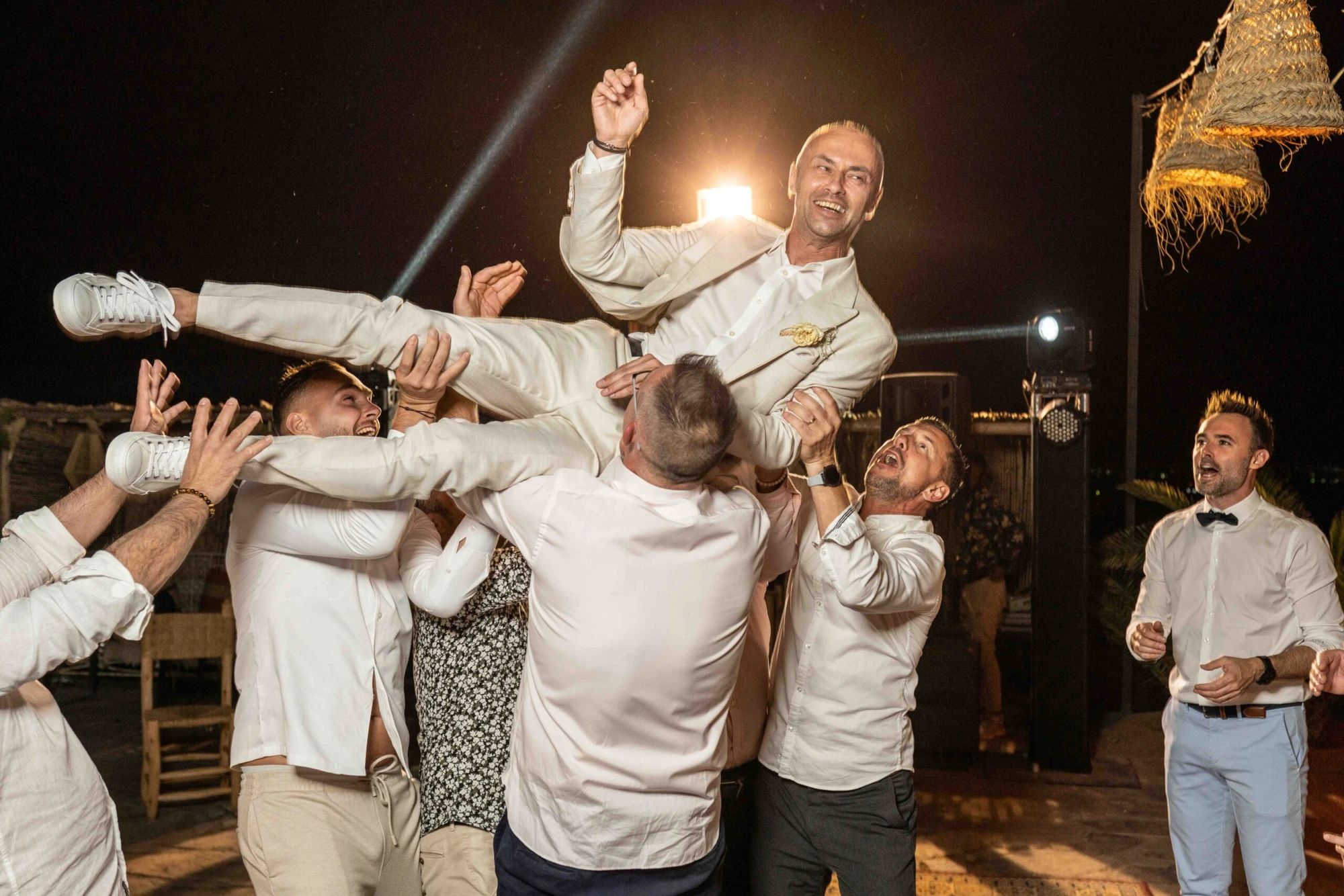 Wedding guests lifting the couple in celebration